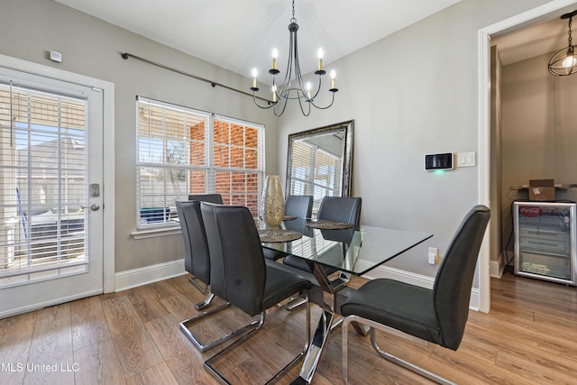 dining area with baseboards, a chandelier, and wood finished floors