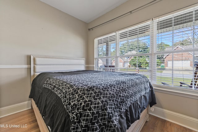 bedroom featuring baseboards and wood finished floors