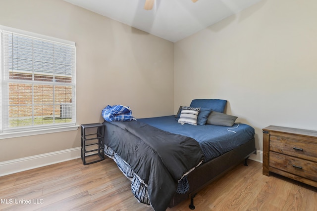 bedroom featuring a ceiling fan, light wood-style flooring, and baseboards