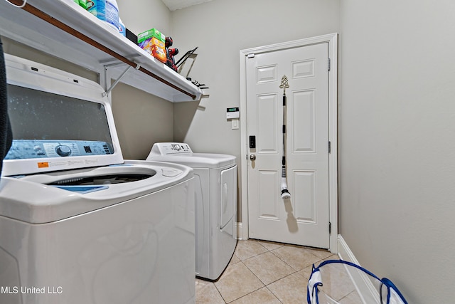 laundry room with laundry area, light tile patterned floors, baseboards, and separate washer and dryer