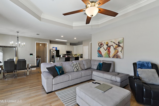 living area featuring recessed lighting, a raised ceiling, light wood-style flooring, and crown molding