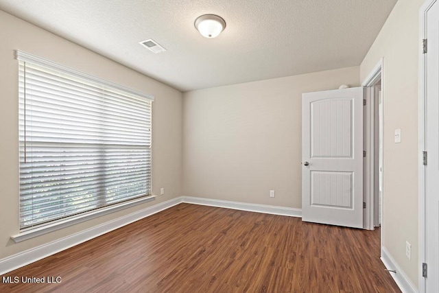 6743 Jessie Hoyt Dr, Olive Branch, MS 38654 - spare room featuring dark wood-style flooring, plenty of natural light, baseboards, and a textured ceiling
