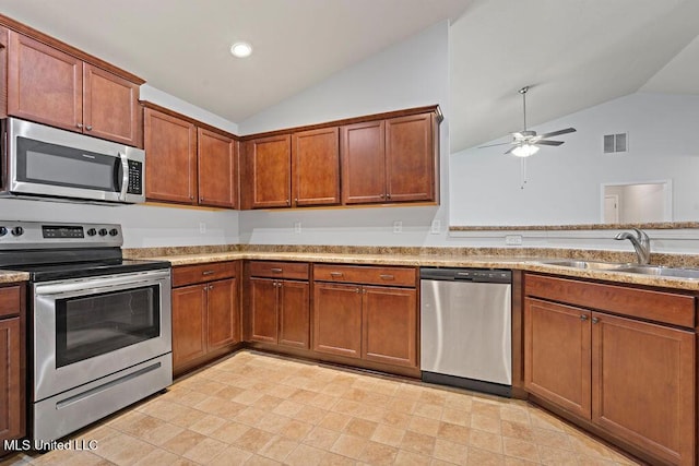 6743 Jessie Hoyt Dr, Olive Branch, MS 38654 - kitchen featuring appliances with stainless steel finishes, a sink, vaulted ceiling, a ceiling fan, and brown cabinets