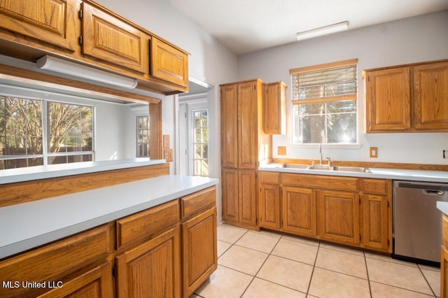 kitchen with sink, stainless steel dishwasher, and light tile patterned floors