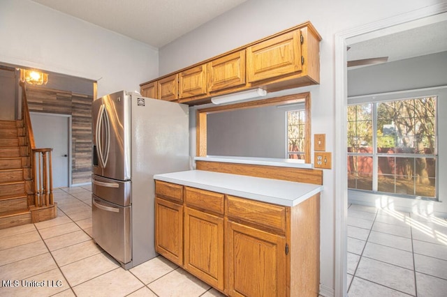 kitchen with light tile patterned flooring and stainless steel refrigerator with ice dispenser