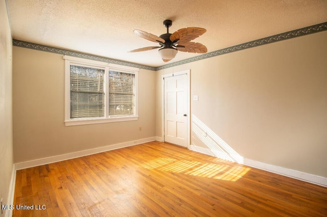 empty room featuring ceiling fan, light hardwood / wood-style flooring, and a textured ceiling