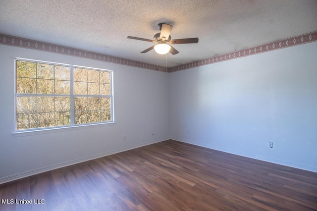 empty room with ceiling fan, a wealth of natural light, a textured ceiling, and dark hardwood / wood-style flooring