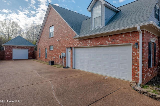 7199 Terrace Stone Dr, Olive Branch, MS 38654 - view of side of home featuring brick siding, central AC, a garage, and roof with shingles