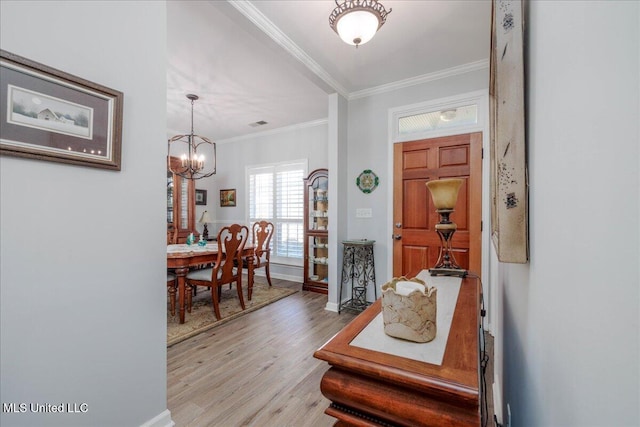 7199 Terrace Stone Dr, Olive Branch, MS 38654 - entryway with light wood finished floors, baseboards, visible vents, ornamental molding, and an inviting chandelier