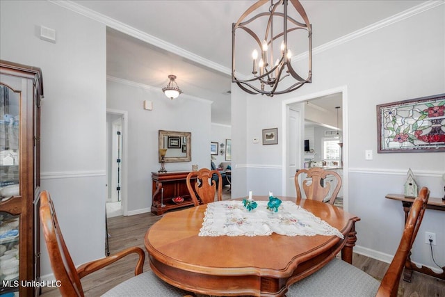 7199 Terrace Stone Dr, Olive Branch, MS 38654 - dining area with baseboards, crown molding, wood finished floors, and an inviting chandelier