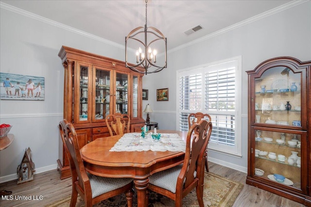 7199 Terrace Stone Dr, Olive Branch, MS 38654 - dining room with a notable chandelier, crown molding, light wood-style floors, and visible vents