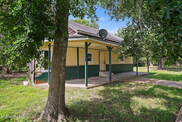 exterior space with a patio and a lawn