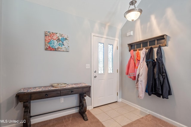 entryway with light tile patterned flooring, vaulted ceiling, and baseboards