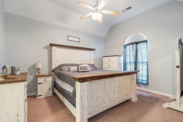 bedroom featuring light carpet, vaulted ceiling, baseboards, and a ceiling fan