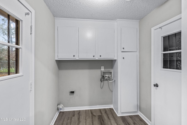 laundry room featuring washer hookup, cabinet space, dark wood-type flooring, a healthy amount of sunlight, and electric dryer hookup