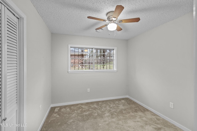 unfurnished bedroom featuring a textured ceiling, ceiling fan, carpet floors, baseboards, and a closet