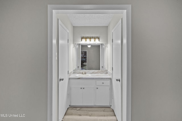 bathroom featuring a textured ceiling, wood finished floors, and vanity