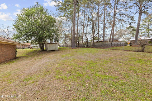 view of yard with a storage unit, fence, and an outbuilding