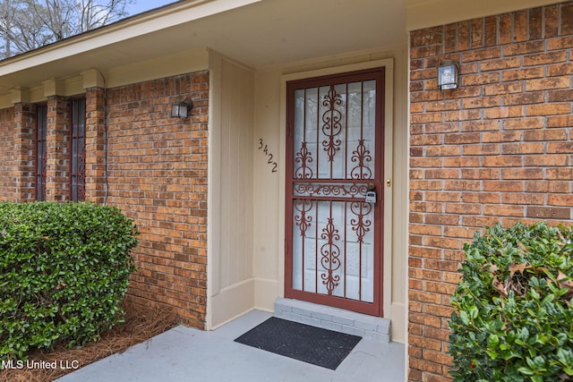 entrance to property featuring brick siding