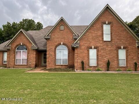 9091 Hunters Ridge Dr, Olive Branch, MS 38654 - traditional-style house featuring a front lawn and brick siding
