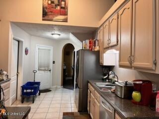 9091 Hunters Ridge Dr, Olive Branch, MS 38654 - kitchen with arched walkways, dishwasher, dark countertops, and light tile patterned floors