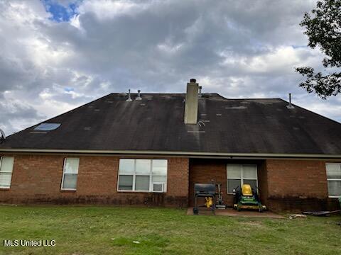 9091 Hunters Ridge Dr, Olive Branch, MS 38654 - rear view of property with a chimney, brick siding, and a lawn
