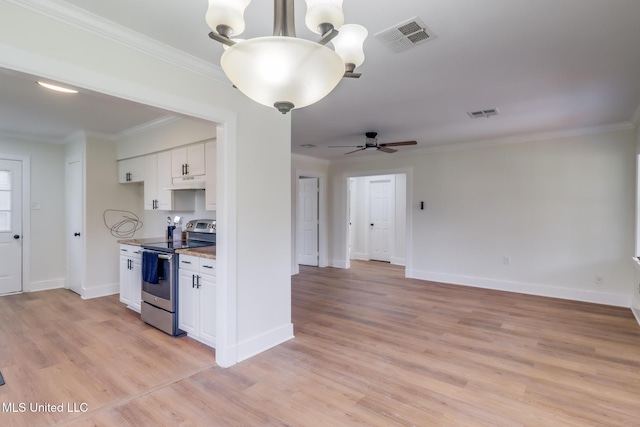 1018 27th St, Gulfport, MS 39501 - kitchen featuring stainless steel range with electric stovetop, white cabinets, light wood-style floors, crown molding, and light stone countertops
