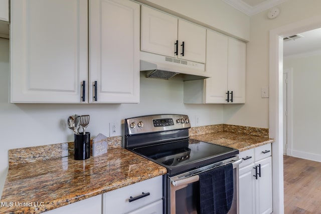 1018 27th St, Gulfport, MS 39501 - kitchen with stainless steel electric range, under cabinet range hood, crown molding, wood finished floors, and white cabinetry