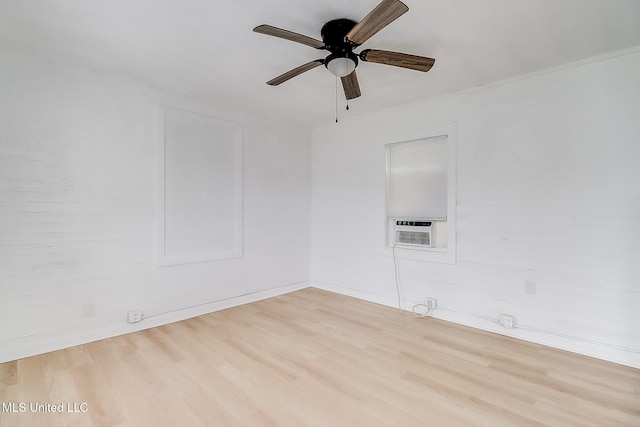 spare room featuring a ceiling fan, cooling unit, and light wood finished floors