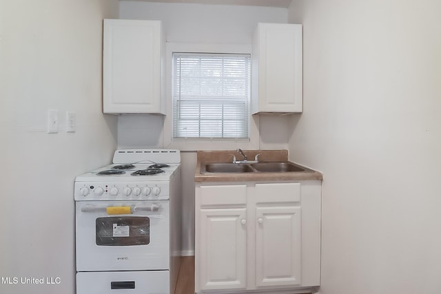 kitchen featuring white cabinets, white electric range, and a sink