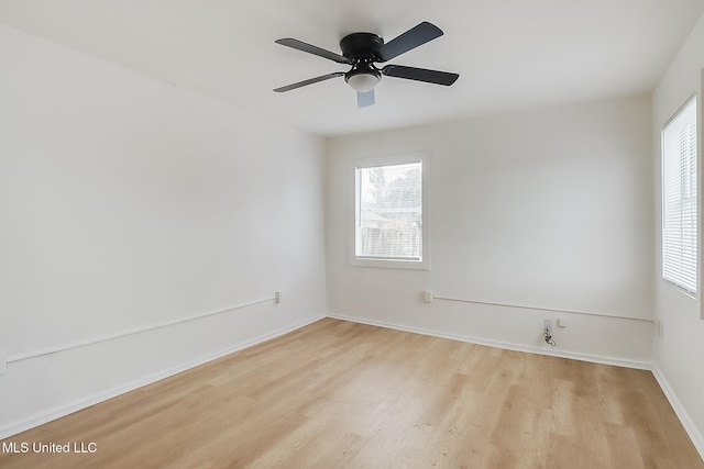 spare room with baseboards, ceiling fan, plenty of natural light, and light wood-style floors