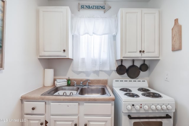 kitchen with a sink, white cabinetry, and electric stove