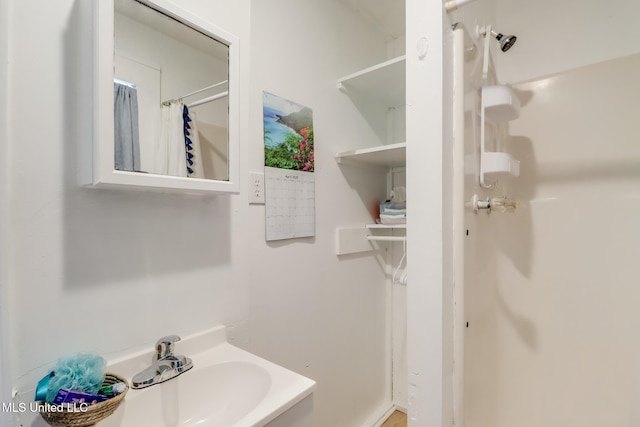 full bath with a shower with shower curtain and a sink