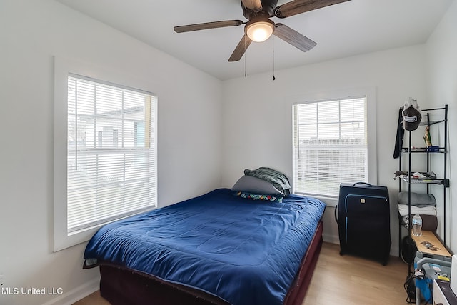 bedroom with ceiling fan, baseboards, and wood finished floors