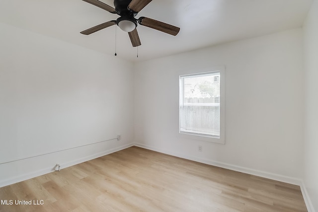 spare room featuring light wood-type flooring, ceiling fan, and baseboards