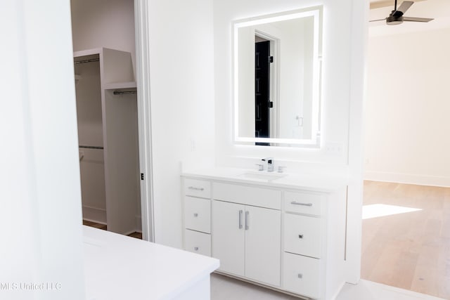 bathroom featuring ceiling fan, vanity, and wood-type flooring