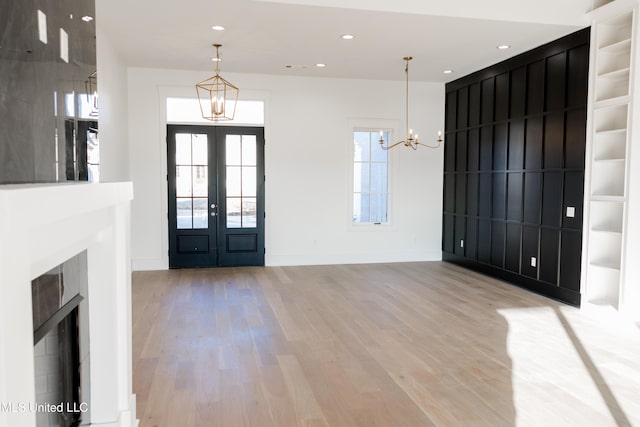 entrance foyer featuring a chandelier, light hardwood / wood-style floors, and french doors