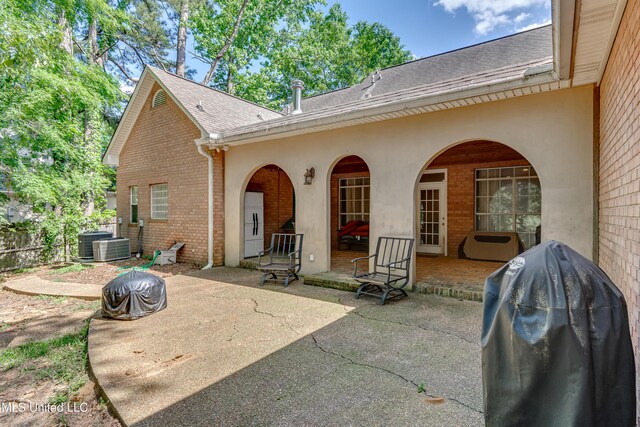 203 Remington Dr, Brandon, MS 39042 - rear view of house featuring roof with shingles, a patio, central AC unit, and brick siding