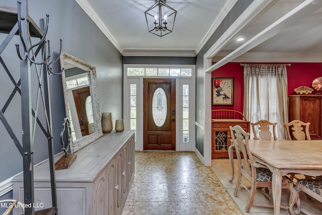 foyer entrance featuring crown molding, baseboards, and an inviting chandelier