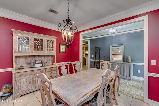 dining room with crown molding, an inviting chandelier, baseboards, light tile patterned floors, and visible vents