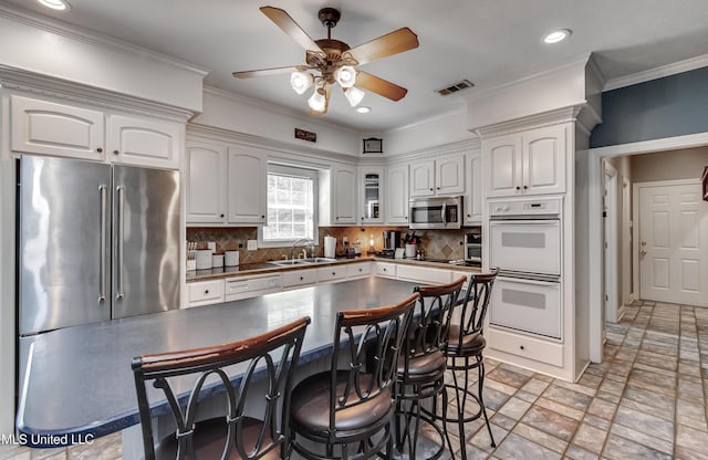 kitchen featuring visible vents, ceiling fan, white cabinets, a sink, and stainless steel appliances