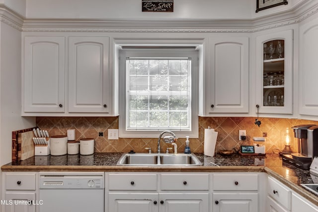 kitchen with white cabinets, dark countertops, a sink, dishwasher, and glass insert cabinets