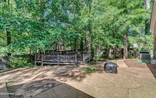 view of gate with a fenced backyard, a patio area, a wooden deck, and central AC unit