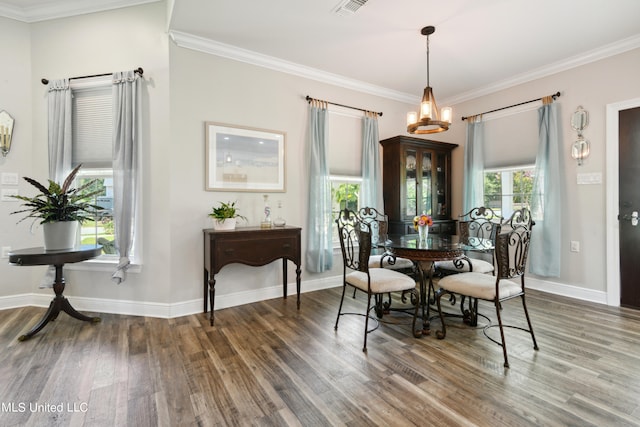 dining space featuring ornamental molding and dark hardwood / wood-style flooring