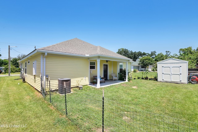 back of property featuring central AC unit, a storage unit, a patio area, and a lawn