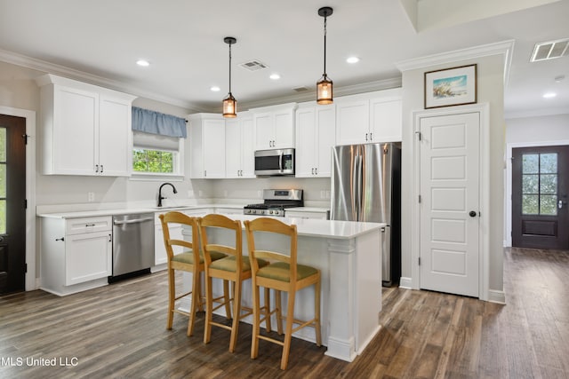 kitchen featuring a healthy amount of sunlight, stainless steel appliances, dark wood-type flooring, and white cabinets