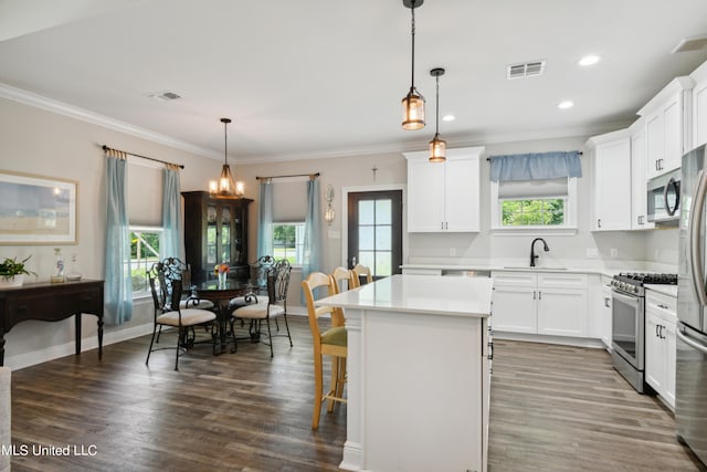 kitchen featuring a center island, appliances with stainless steel finishes, pendant lighting, and plenty of natural light