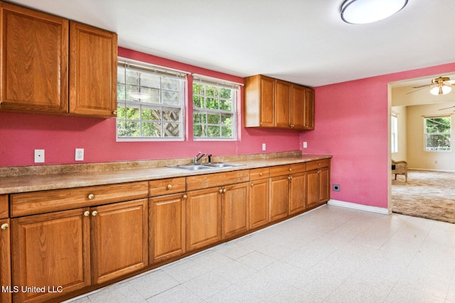 301 N Necaise Ave, Bay Saint Louis, MS 39520 - kitchen with a sink, brown cabinetry, baseboards, and light countertops
