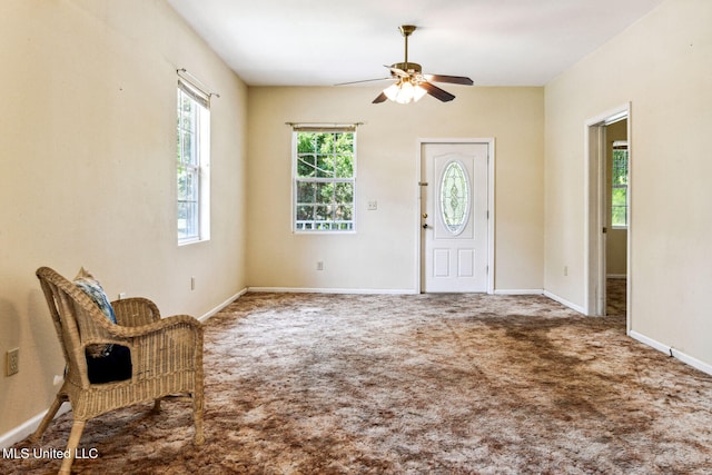 carpeted entryway featuring ceiling fan