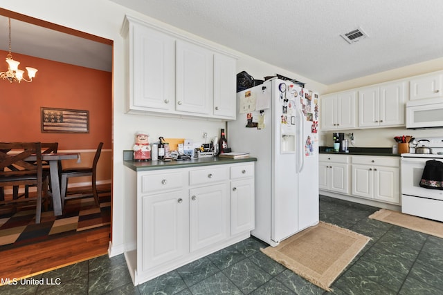 kitchen with visible vents, dark countertops, white appliances, white cabinets, and a notable chandelier